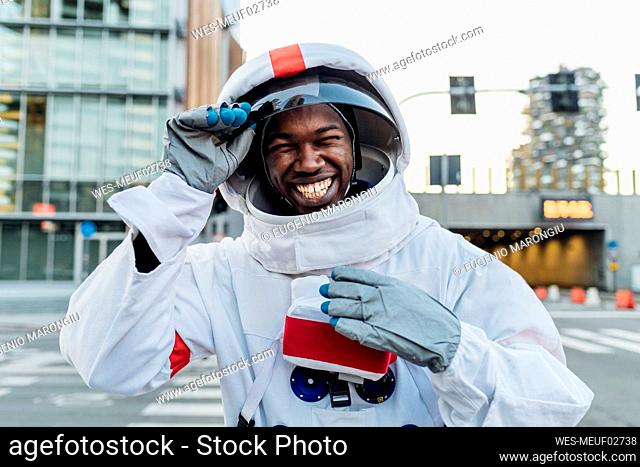 Cheerful male astronaut holding space helmet
