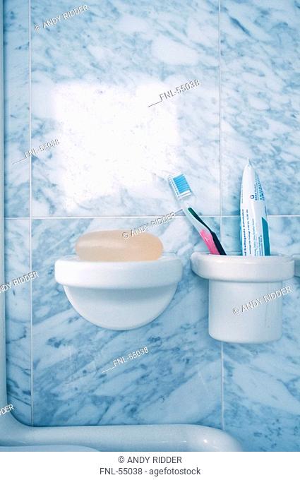 Toothbrush and paste in toothbrush holder with bar of soap beside it
