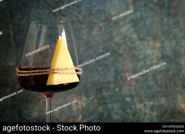 Dry Glass Of Red Wine and Cheese on stone background