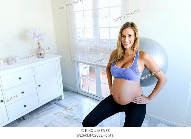 Portrait of smiling pregnant woman practicing with fitness ball