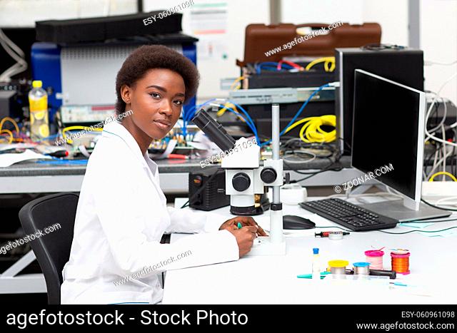 Scientist african american woman working in laboratory with tech instruments and microscope. Research and development of electronic devices by color black woman