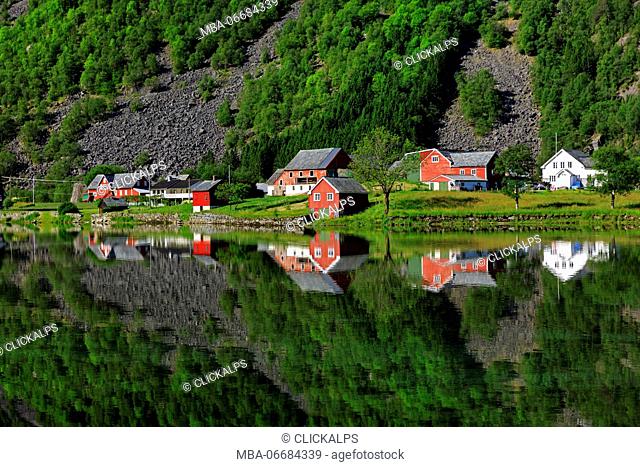 Perfect reflection of some typical norvegia houses into a lake in late spring, Odda, Hardaland, Norway