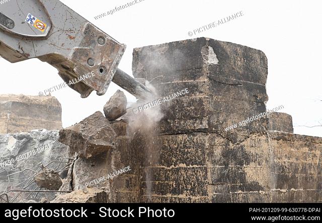09 December 2020, Mecklenburg-Western Pomerania, Sellin: An excavator with hydraulic chisel hammers at the old NVA bunker while it is being demolished