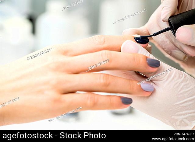 Photos of manicure at the salon. Master gets a new paint gray fingers on different - different shades