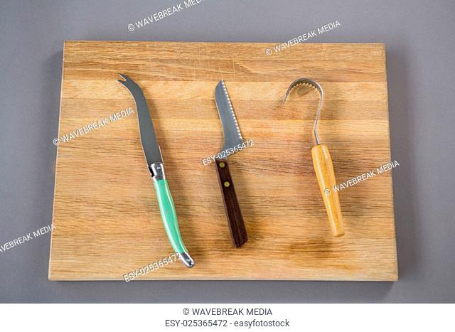 Cheese cutting tools on wooden board