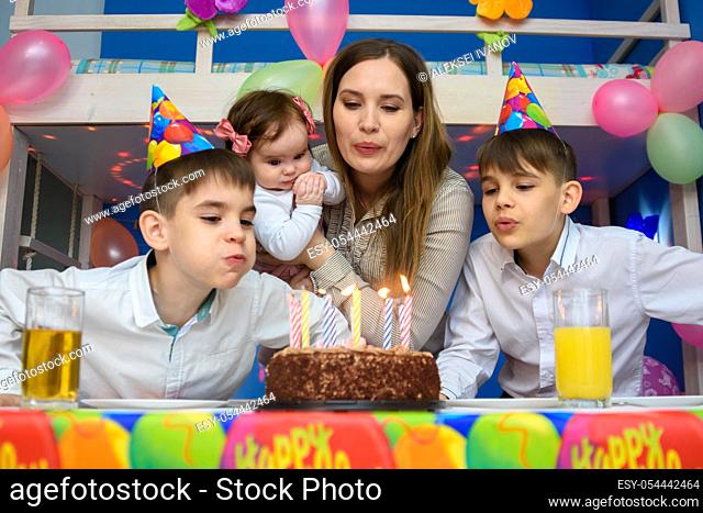 Family blowing candles on birthday cake