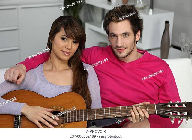 Woman playing the guitar for her boyfriend