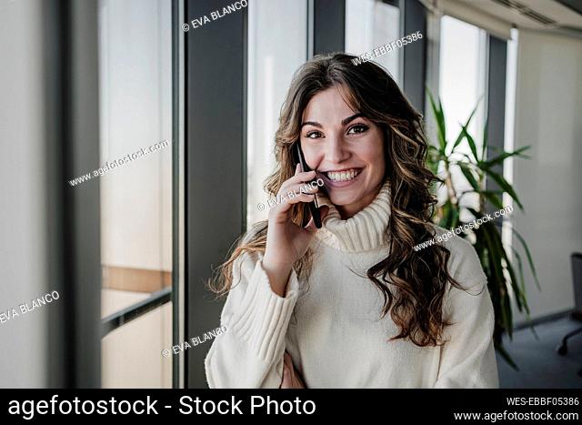 Working woman talking on smart phone in office