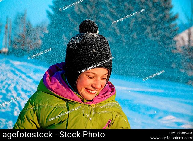 A happy child without a mask laughs and rejoices on a walk in winter. Portrait of a boy on a Sunny winter day. Village scene