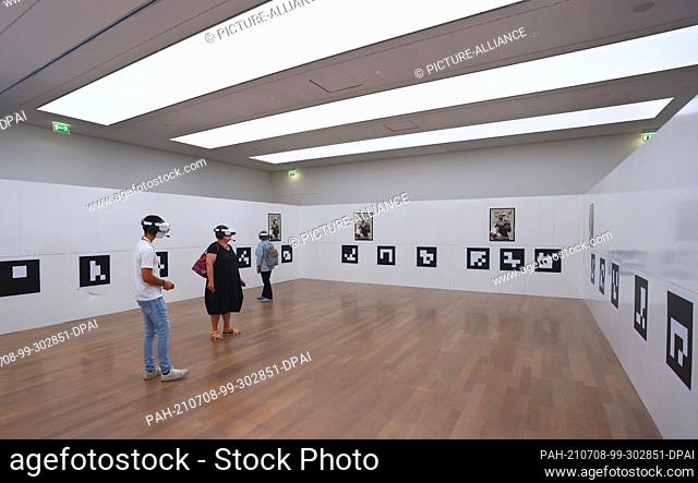 06 July 2021, Baden-Wuerttemberg, Stuttgart: Visitors to the art museum stand with virtual reality glasses on in a room in which only QR codes hang on the walls