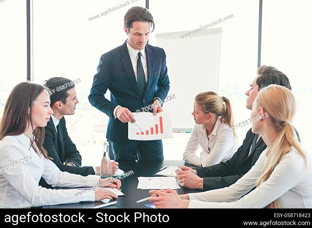 Business man showing financial statistics graph at meeting