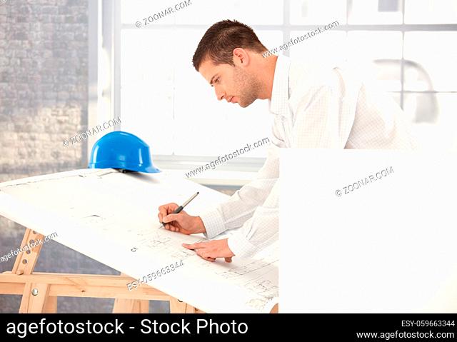 Young engineer busy by working, using drawing table