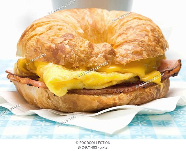 Croissant with scrambled egg, cheese & bacon close-up