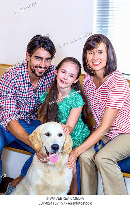 Smiling family sitting and posing with their dog