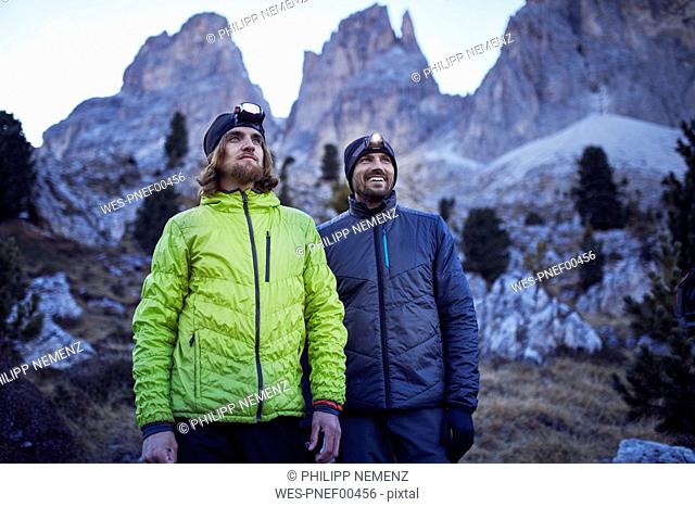Two confident men wearing headlamps in the mountains