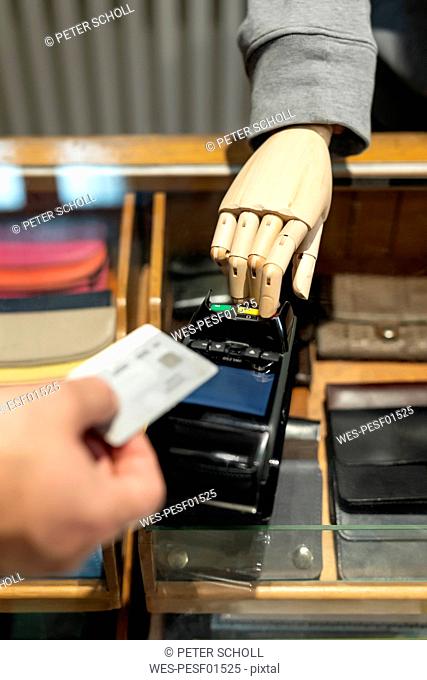 Customer paying with creditcard, robot assisting