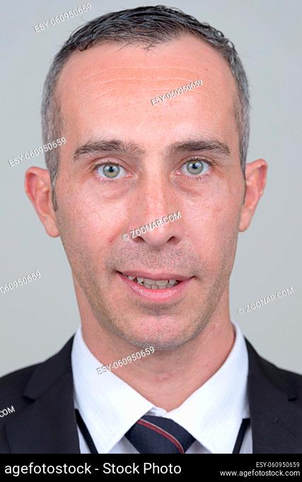 Studio shot of mature handsome businessman in suit against white background