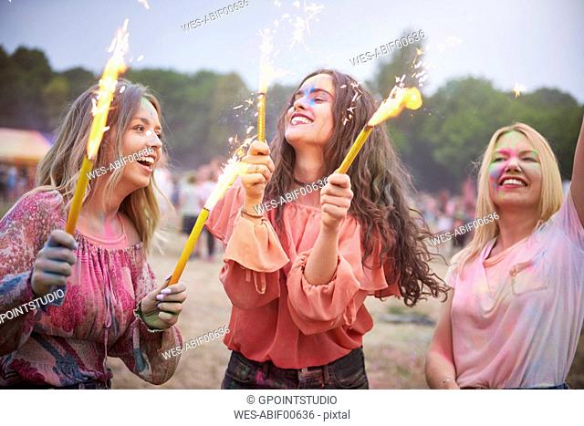 Friends with sparklers dancing at music festival