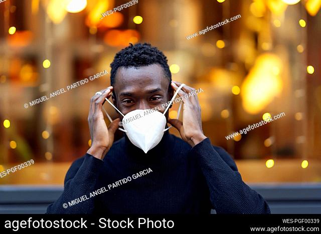 Young man wearing face mask while standing outdoors during Covid-19