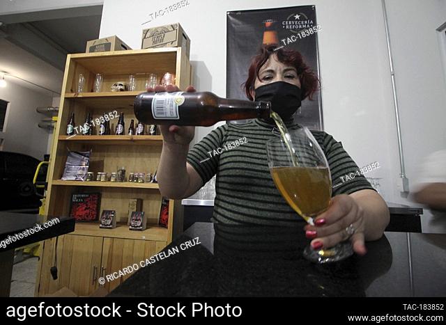 MEXICO CITY, MEXICO - NOVEMBER 13: A person wears protective mask while serves craft beer during 'Beer City tour' where beer producers present their products to...