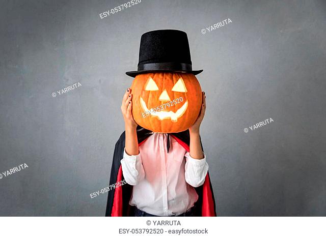 Funny child dressed Halloween costume. Kid painted terrible vampire. Autumn holiday concept