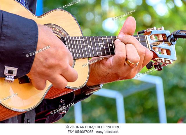 Live musical performance of Brazilian popular music called chorinho with little acoustic guitar with four strings