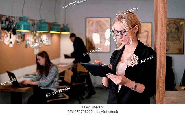 4k. closeup beautiful blonde businesswoman uses a touchscreen tablet in the modern startup office