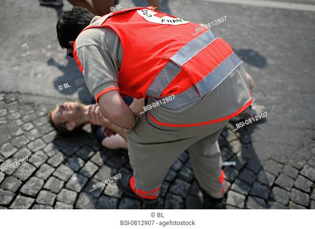 EMERGENCY AID WORKER Photo essay. Paris Marathon, April 2007. First aid attendant from the French Red Cross with an injured person