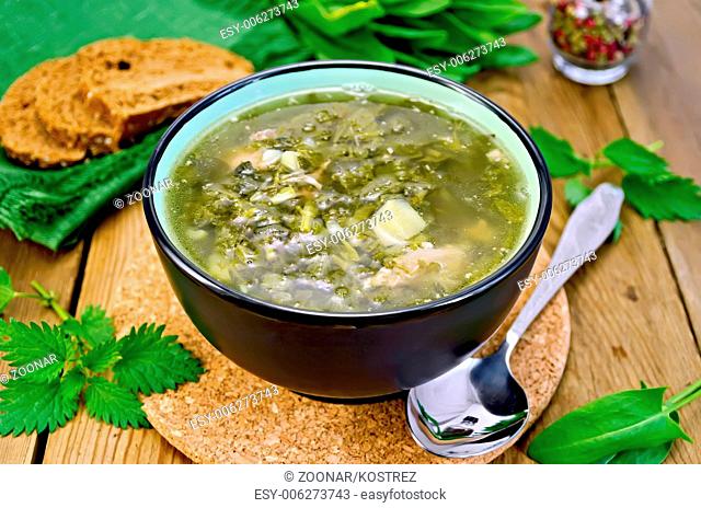 Soup green of sorrel and nettles with bread on the board