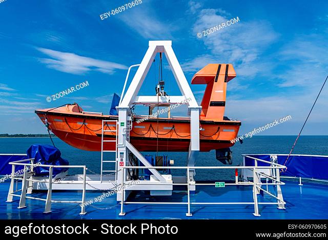 Tars, Denmark - 10 June, 2021- view of an orange life raft on a mount of a passenger ferry with open ocean behind
