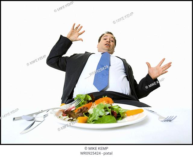 Overweight businessman falling off his chair at lunch