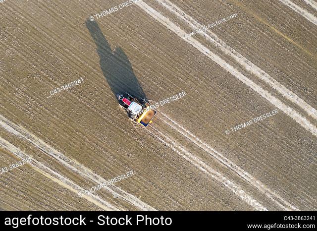 Tractor sowing rice seeds in a flooded rice field in May. Aerial view. Drone shot. Ebro Delta Nature Reserve, Tarragona province, Catalonia, Spain