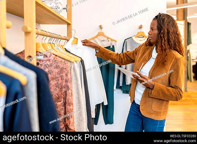 Businesswoman with tablet PC working in clothing store
