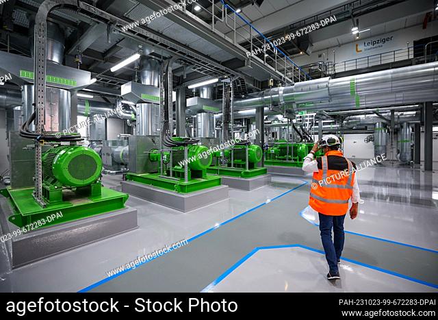 23 October 2023, Saxony, Leipzig: The power plant manager walks through the pump hall for district heating in the new combined heat and power plant South
