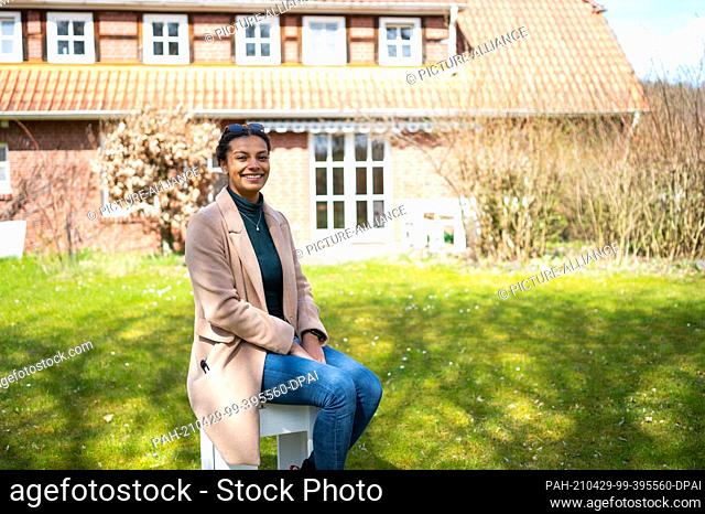 24 April 2021, Lower Saxony, Bockum: Leonie Laryea, employee at the SOS-Hof Bockum sits in front of one of the residential houses