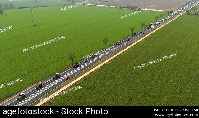 18 December 2023, Lower Saxony, Uelzen: Farmers drive their tractors at walking pace along federal highway 4 (photo taken with a drone)