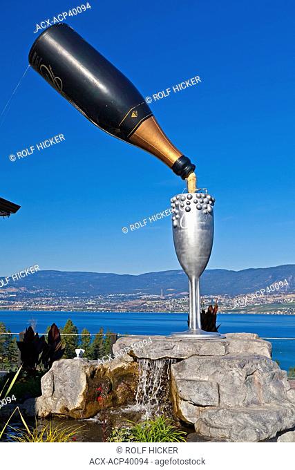 Large bottle of sparkling wine and goblet in the Summerhill World Peace Park at the Summerhill Pyramid Winery, a certified organic vineyard, Kelowna, Okanagan