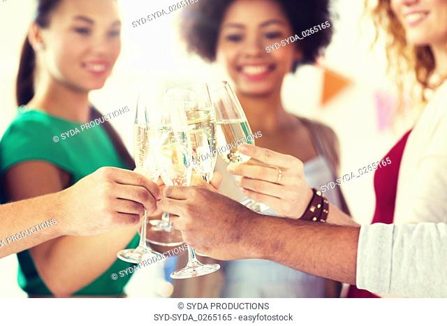 friends clinking glasses of champagne at party