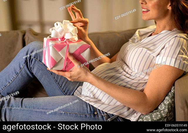 happy smiling pregnant woman with gift box at home