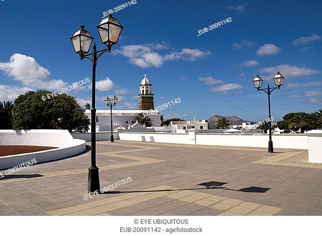 Teguise, the former capital of the island. Large open square known as Parque le Mareta with tower of Church of Nuestra Senora de Guadalupe’s and street lamps
