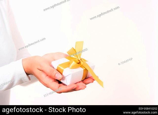 Valentine's Day. Woman beauty hands holding small gift package box present wrapped paper with ribbon isolated on white background, Birthday, New year, Christmas