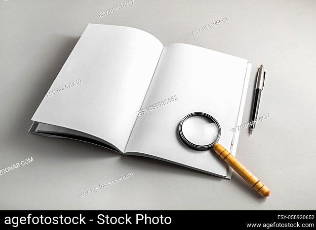 Book with with blank pages, magnifier and pencil on paper background