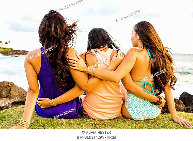 Pacific Islander women hugging near beach