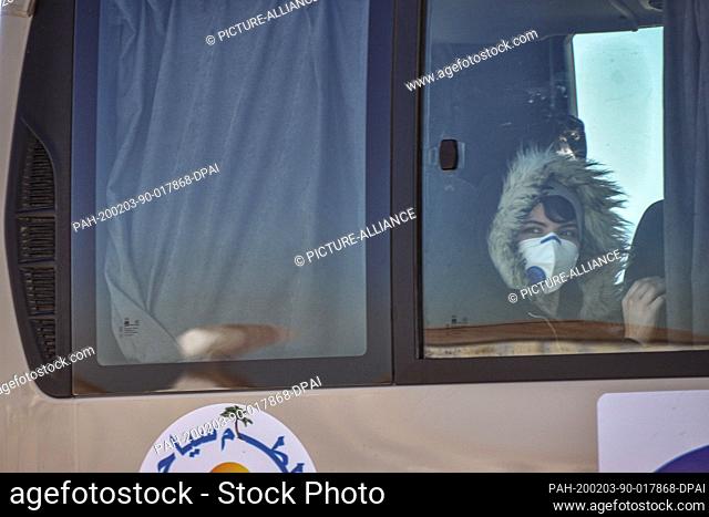 03 February 2020, Algeria, Algiers: Passengers, from Algeria, Libya and Mauritania, wearing surgical masks, leave on a transport bus at the the Houari...