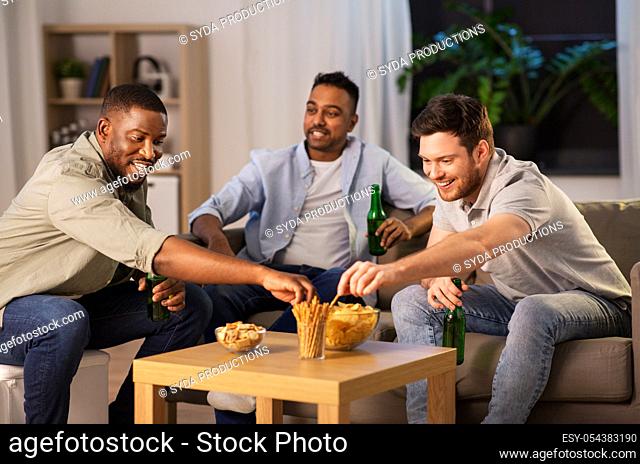 male friends drinking beer with crisps at home