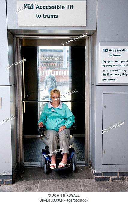 Woman wheelchair user exiting accessible lift to tram stop