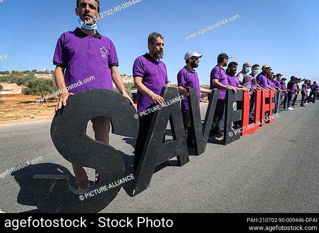 02 July 2021, Syria, Sarmada: Members of the Violet relief organization take part in a protest, organized by civil society organizations