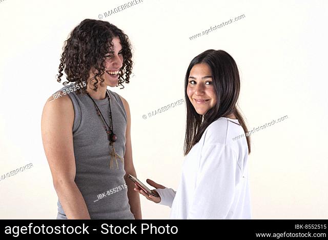 Portrait of a young couple dressed in yoga clothes laughing over white background. Studio shot