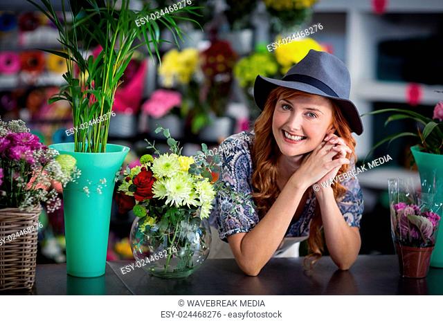 Happy female florist leaning in flower shop