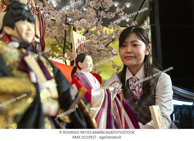 An employee looks at Japanese 'hina' dolls modeled after shogi player Sota Fujiii (L) and figure skater Rika Kihira (R) at Kyugetsu Company's showroom